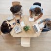 view-from-business-startup-teamwork-concept-startup-partners-sitting-coworking-space-talking-about-future-project-looking-through-examples-work-laptop-digital-tablet